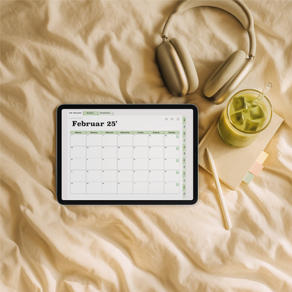 Monatsansicht im digitalen Semesterplaner 2025/26 in Grün – iPad auf Bettdecke mit Kopfhörern, Notizbuch und Iced Matcha